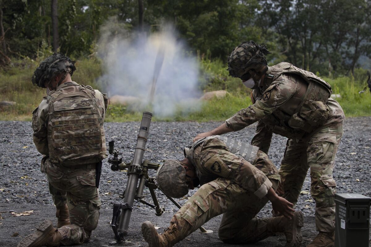 Cadets learn to fire mortars, Friday, Aug. 7, 2020, at the U.S. Military Academy in West Point, N.Y. The pandemic is not stopping summer training. Cadets had to wear masks this year for much of the training. (AP Photo/Mark Lennihan)