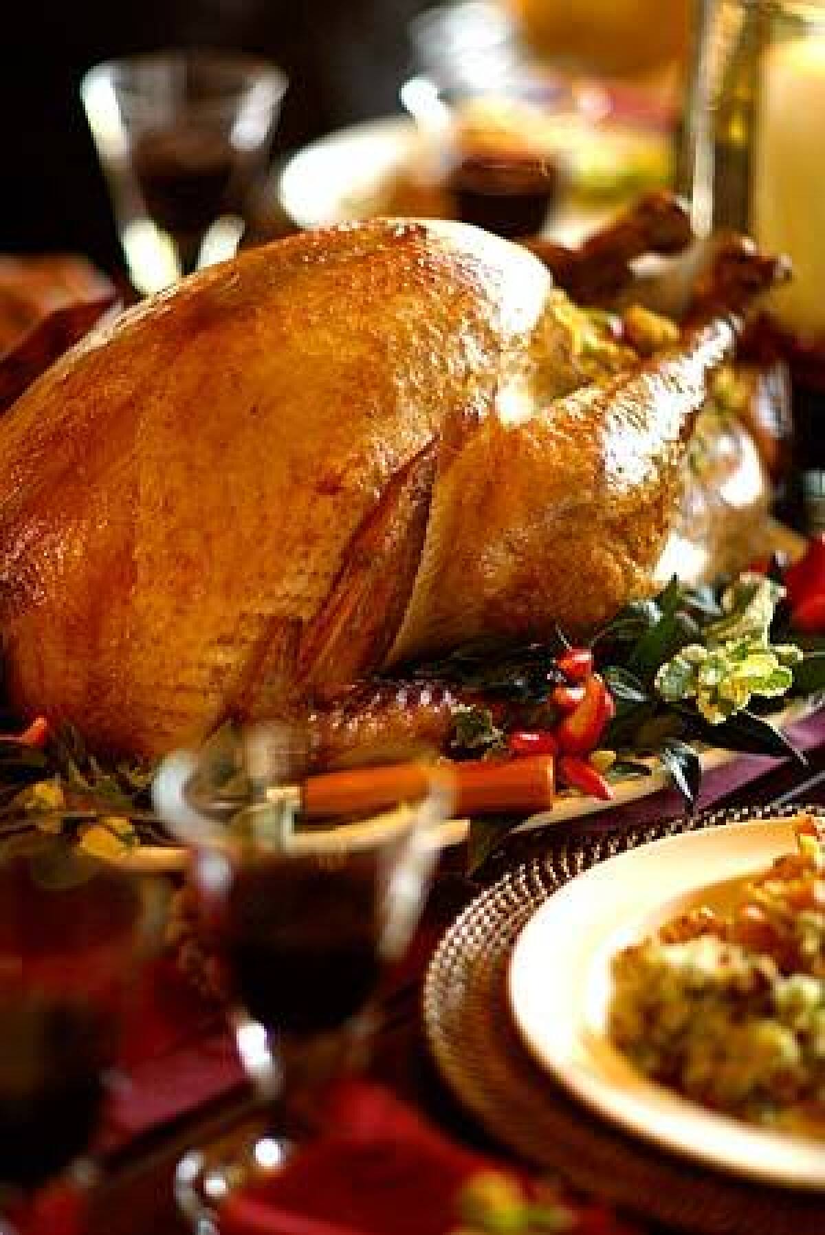 A MEAL TO LINGER OVER: Soy-brined turkey is the centerpiece of a Thanksgiving dinner, served with sausage-cornbread stuffing.