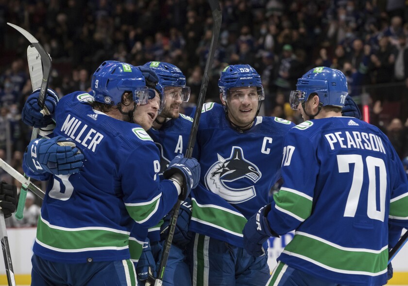 Vancouver Canucks' J.T. Miller, from left to right, Brock Boeser, Oliver Ekman-Larsson, of Sweden, Bo Horvat and Tanner Pearson celebrate Boeser's goal against the Los Angeles Kings during second period of an NHL hockey game in Vancouver, British Columbia, Monday, Dec. 6, 2021. (Darryl Dyck/The Canadian Press via AP)