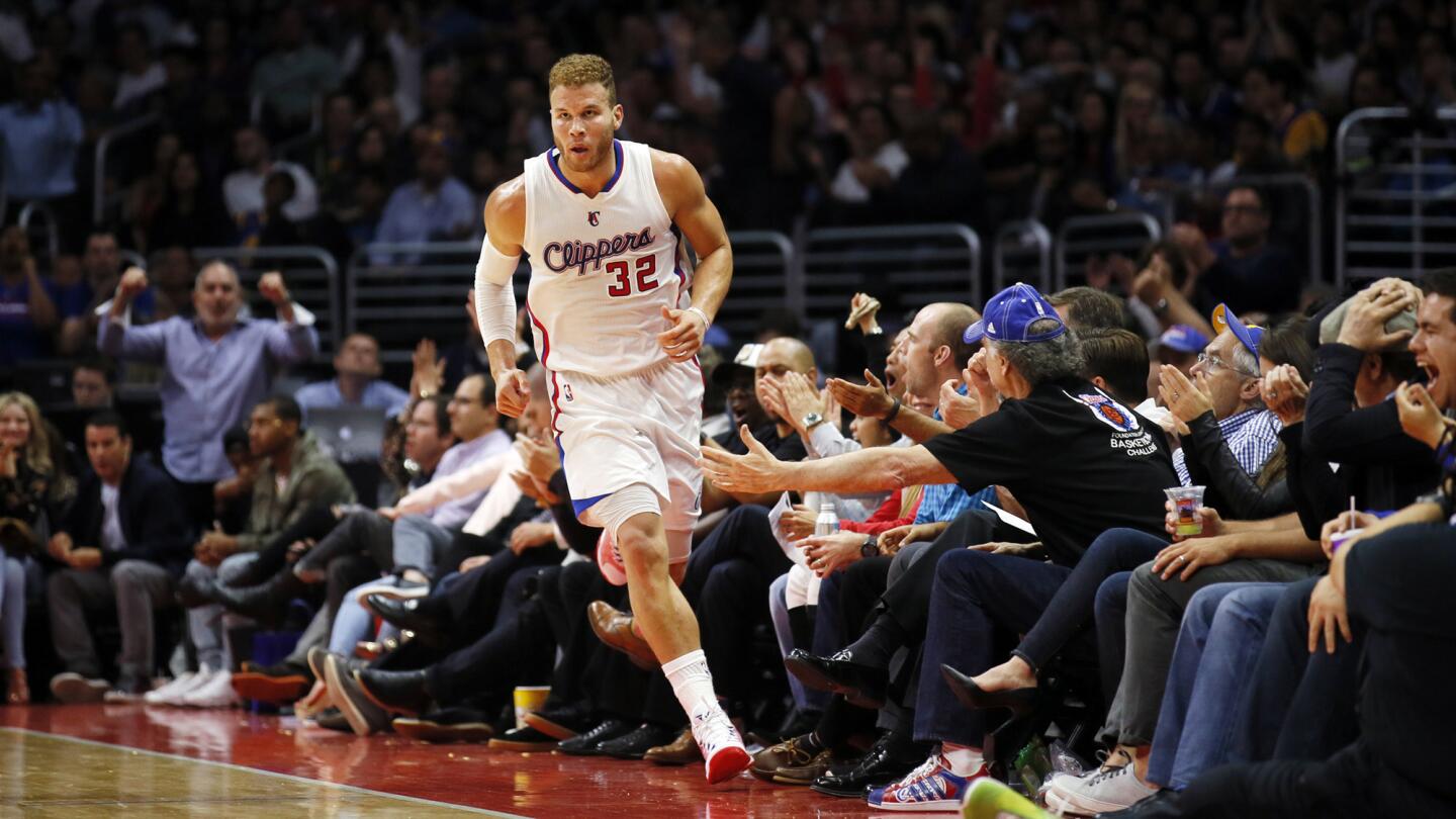 After scoring against the Golden State Warriors during the second half of an NBA basketball game on March 31, 2015, in Los Angeles, the Clippers' Blake Griffin runs past fans holding out their hands for high-fives.