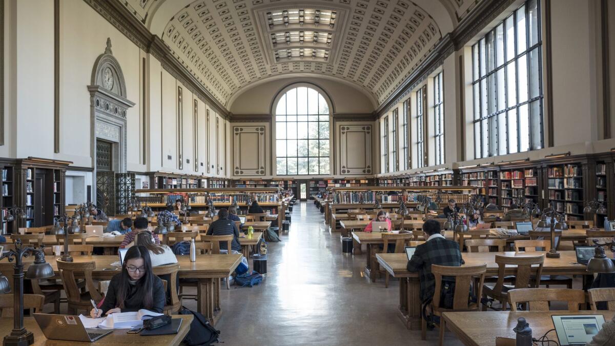 Students read in the main library at UC Berkeley. With its rows and rows of books, the setting is a stark contrast to the two bookless floors at Moffitt Library.