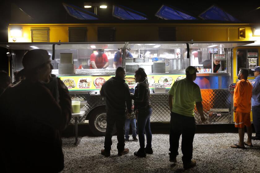 HESPERIA-CA-FEBRUARY 13, 2020: Customers gather outside the Tacos La Madrina truck parked in Hesperia on Thursday, February 13, 2020. (Christina House / Los Angeles Times)