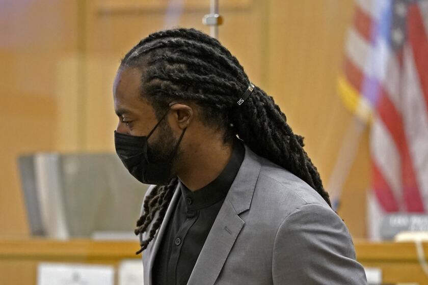 FILE - Richard Sherman stands up to leave a King County District Court hearing, Friday, July 16, 2021, in Seattle.