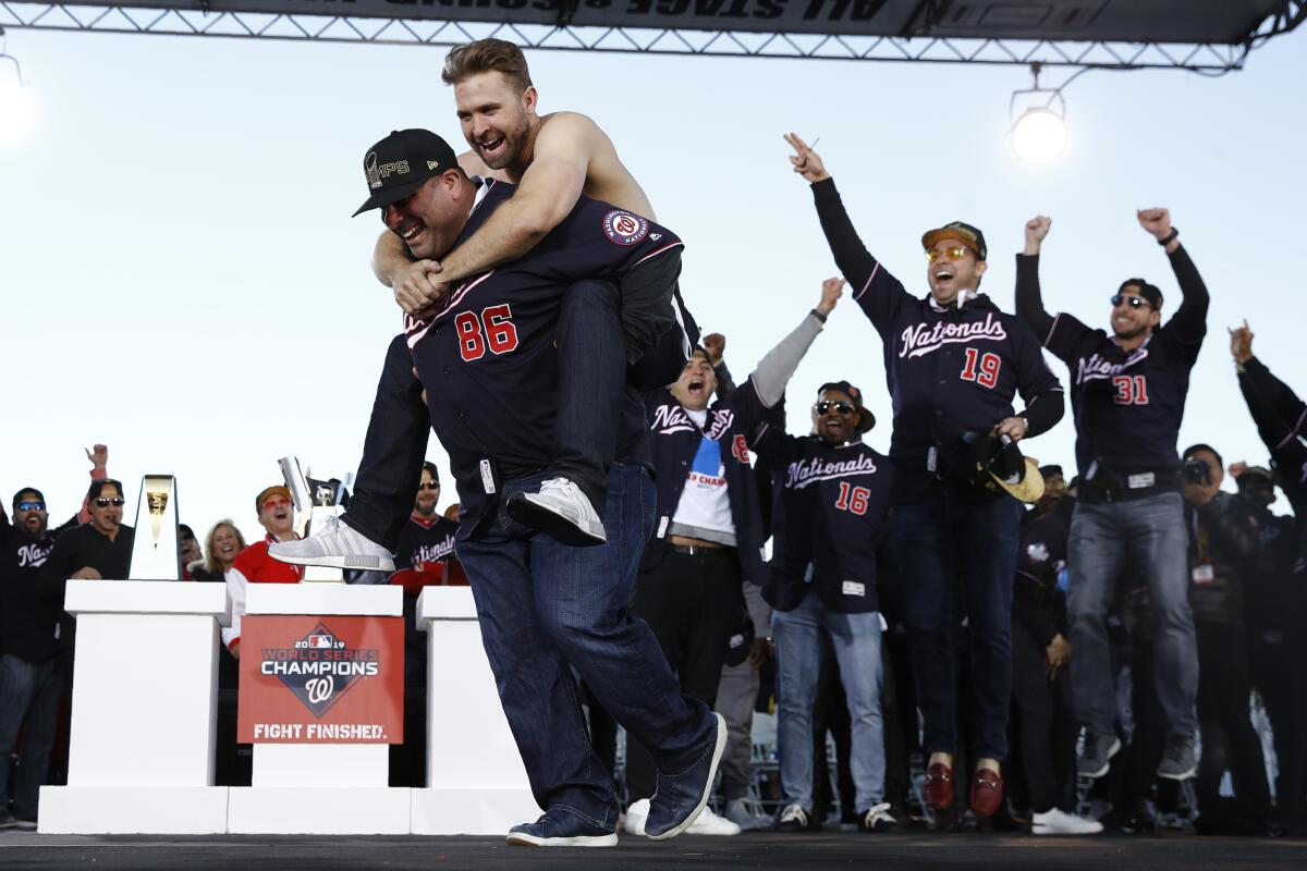 Brian Dozier rides on Ali Modami's shoulders in front of teammates at a rally