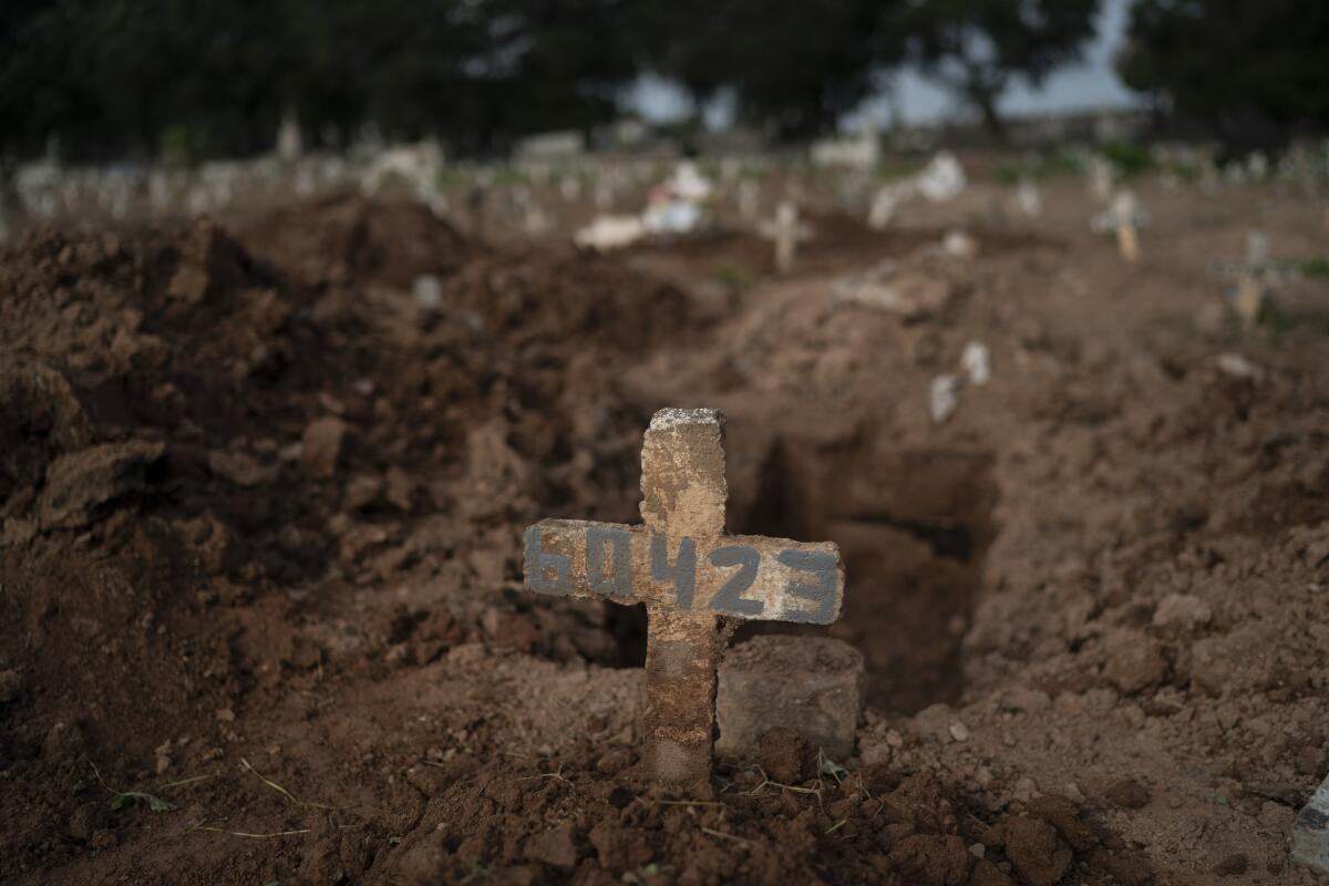 A cross marks the grave of Paulo Jose da Silva, 57, who died of COVID-19 in Rio de Janeiro.