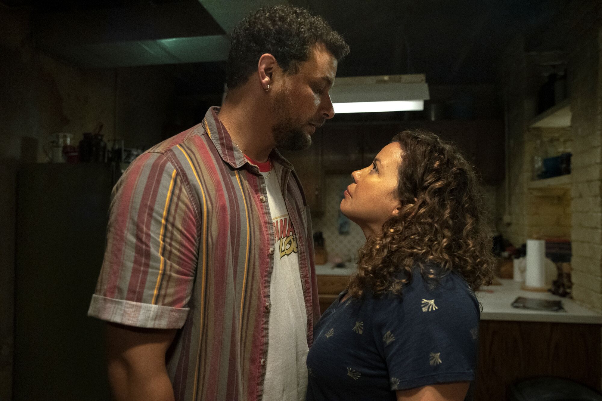 A man looks down at a woman with curly hair.