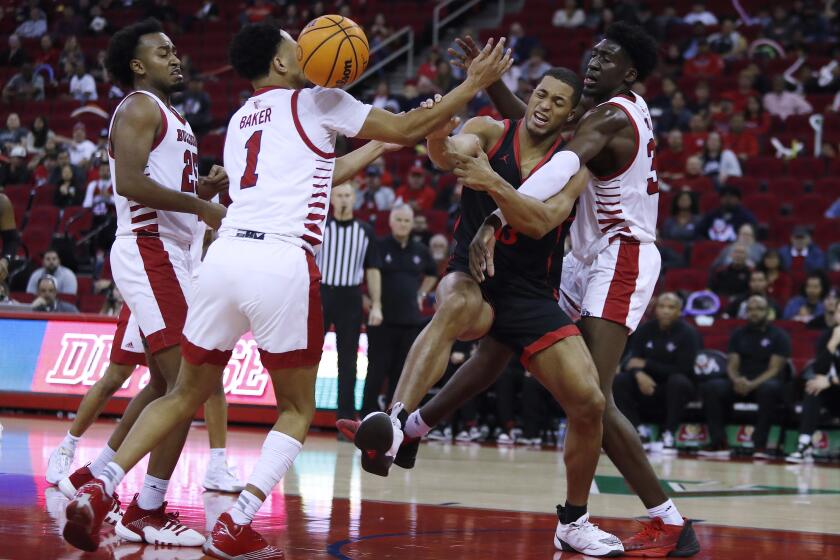 San Diego State's Jaedon LeDee is sandwiched between Fresno State's Jemarl Baker (1) and Eduardo Andre during the second half of an NCAA college basketball game in Fresno, Calif., Wednesday, Feb. 15, 2023. (AP Photo/Gary Kazanjian)