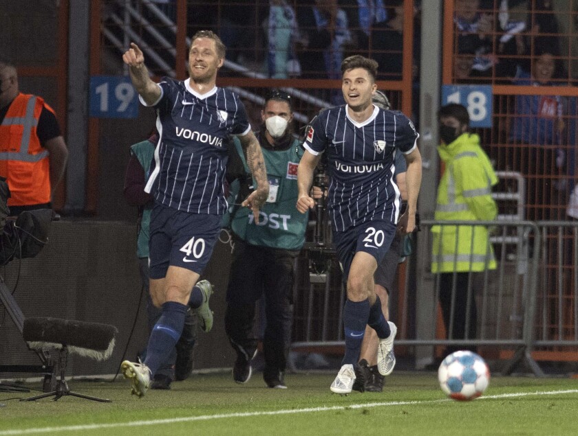 Bochum's Sebastian Polter, left, celebrates with teammate Elvis Rexhbecaj after scoring the first goal of the game during the German Bundesliga soccer match between VfL Bochum and Arminia Bielefeld at the Vonovia Ruhrstadion in Bochum, Germany, Friday, May 6, 2022. (Bernd Thissen/dpa via AP)