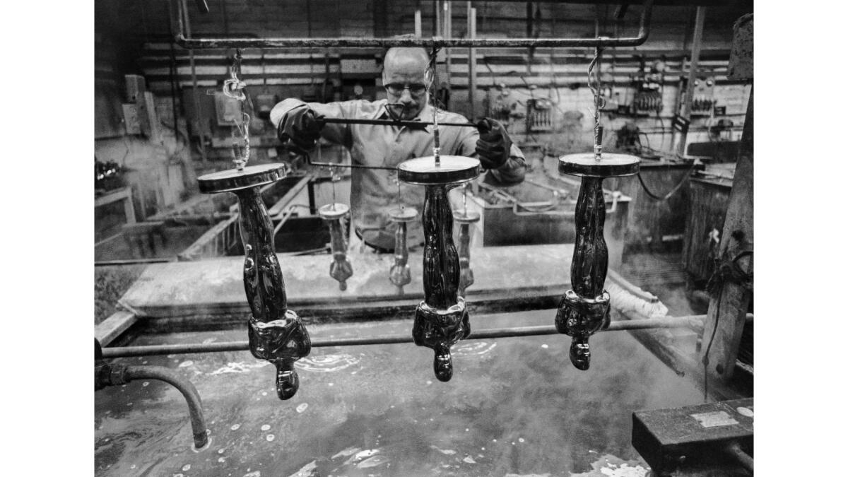 oscar statuettes hang upside during the manufacturing process