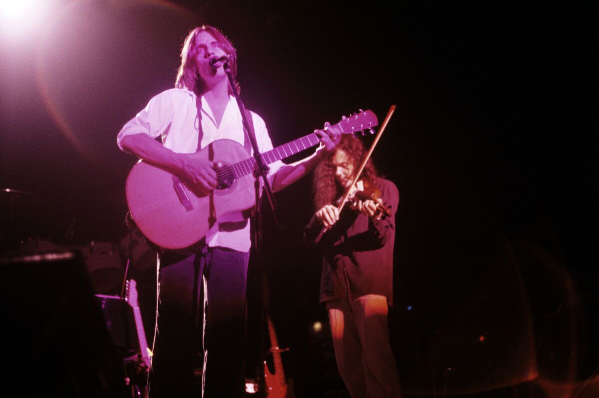 Two musicians are playing on stage
