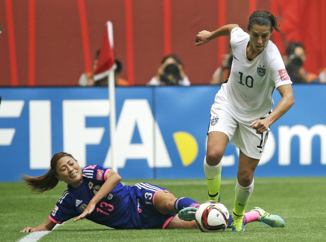 2015年のワールドカップでアメリカのカーリーロイドがボールを動かすと、日本の大辻ルミ（左）が倒れます。