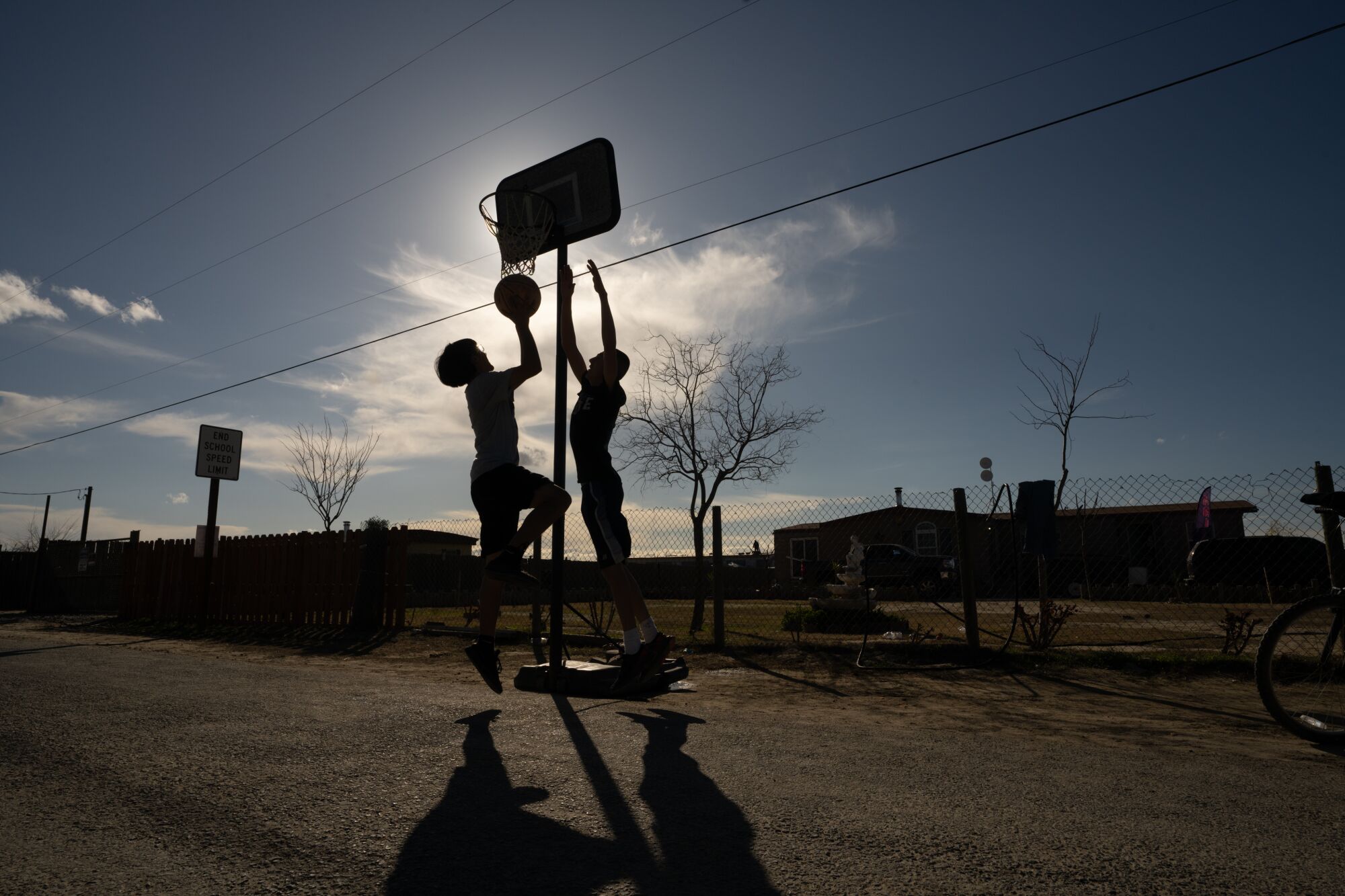 Two boys play basketball in the middle of the street in the small city of Allensworth.