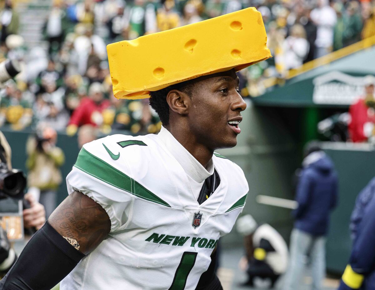 New York Jets cornerback Sauce Gardner (1) wears a cheesehead as he reacts after beating the Green Bay Packers.