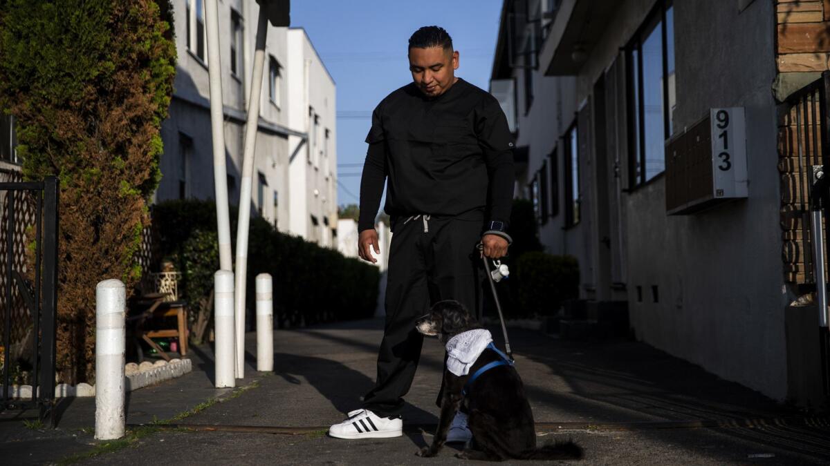 Maynor Garcia stands with the dog of his late brother Gabriel Dirzo, who L.A. County medical officials suspect died after snorting cocaine laced with fentanyl.