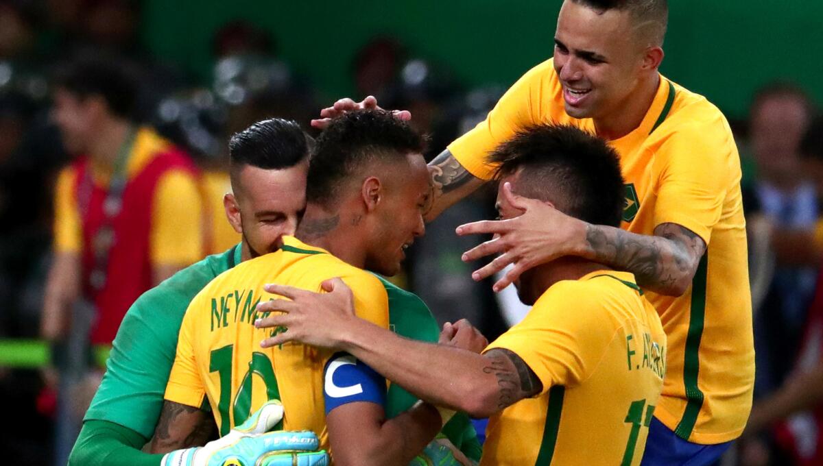 Neymar (10) is swarmed by Brazilian teammates after scoring the deciding kick in the shootout against Germany on Saturday.