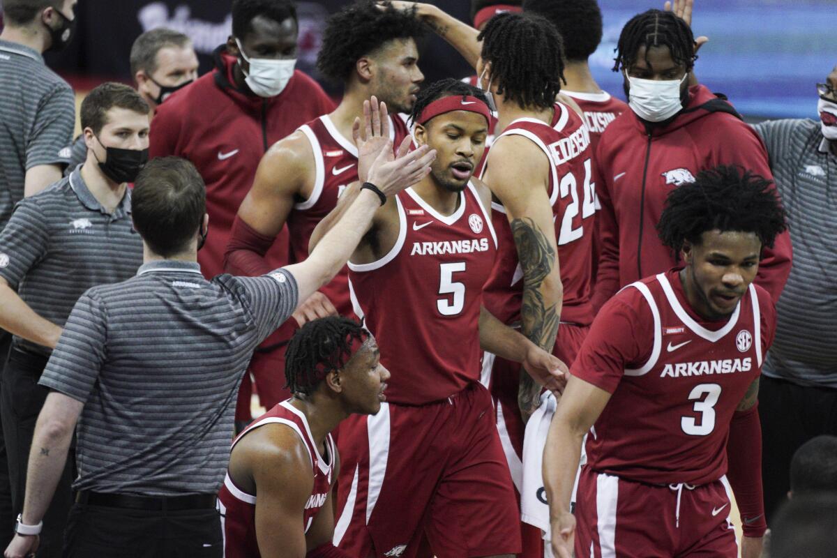 Arkansas guard Moses Moody (5) high-fives a member of the coaching staff during a timeout in the second half of the team's NCAA college basketball game against South Carolina on Tuesday, March 2, 2021, in Columbia, S.C. (AP Photo/Sean Rayford)