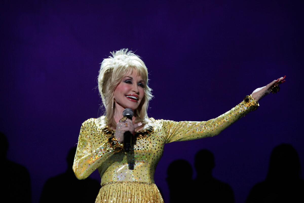Dolly Parton, shown during a 2011 performance in Los Angeles, will release a new album, 'Blue Smoke,' and undertake a supporting world tour in 2014.