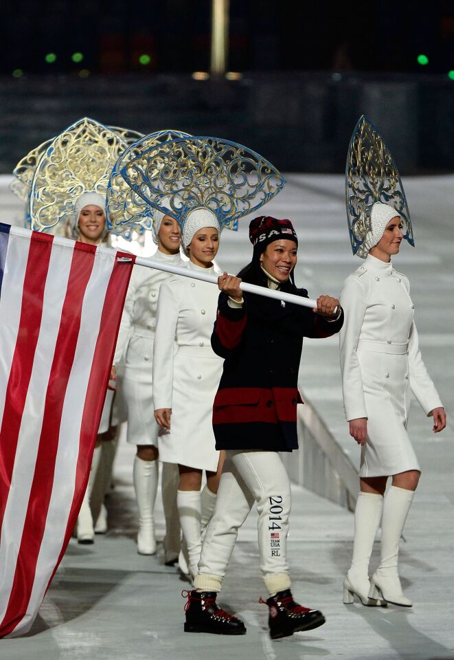 Hockey player Julie Chu of the United States enters with the flag during the 2014 Sochi Winter Olympics Closing Ceremony.