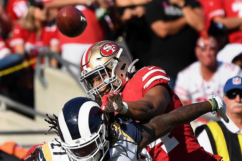 LOS ANGELES, CALIFORNIA OCTOBER 13, 2019-Rams running back Darrell Henderson Jr. has the ball knocked away by 49ers linebacker Fred Warner on apass attempt in the 3rd quarter at the Coliseum Sunday. (Wally Skalij/Los Angeles Times)