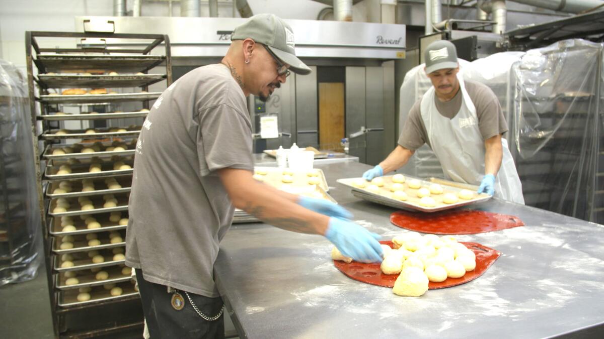 Luis Bahena, left, and Ernie Jimenez work in the bakery at Homeboy Industries, which has an 18-month job training program.