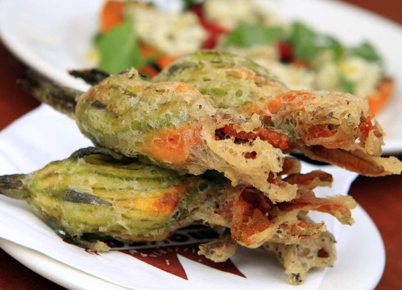 Fried squash blossoms are coated in a crisp batter and stuffed with ricotta.