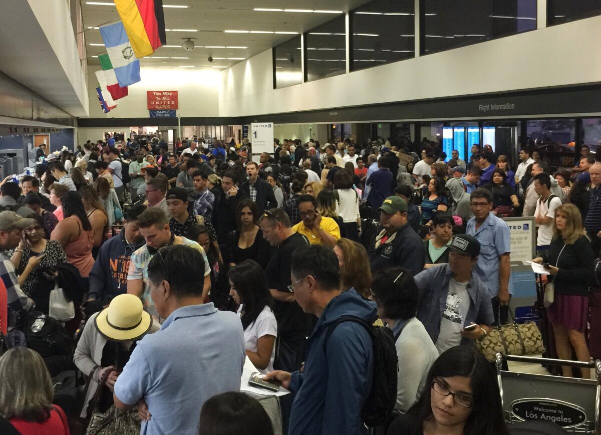 Travelers gather at Los Angeles International Airport as United Airlines experienced computer problems on July 8, 2015.