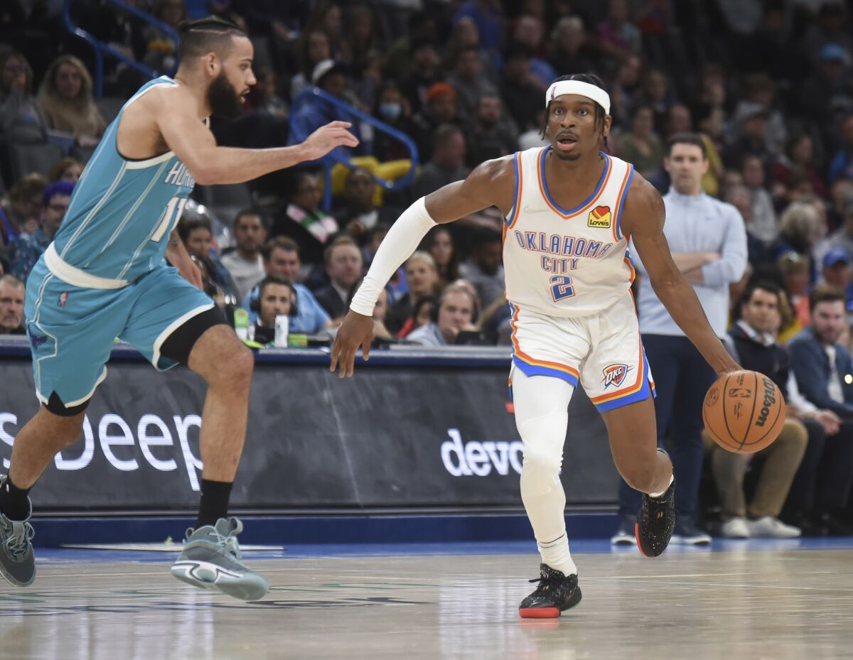 Oklahoma City Thunder guard Shai Gilgeous-Alexander (2) gets past Charlotte Hornets guard Cody Martin (11) in the second half of an NBA basketball game, Monday, March 14, 2022, in Oklahoma City. (AP Photo/Kyle Phillips)