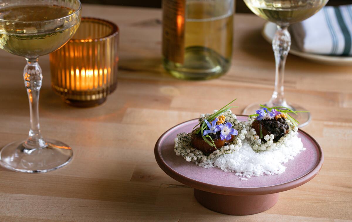 A photo of two "raw" bar items, made from vegetables, atop rice crackers.