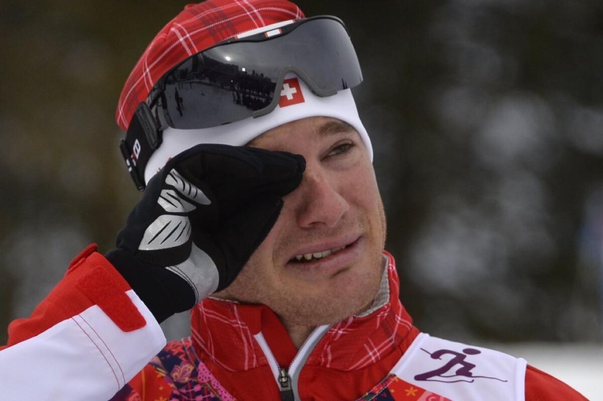 Dario Cologna wipes away tears after his victory.
