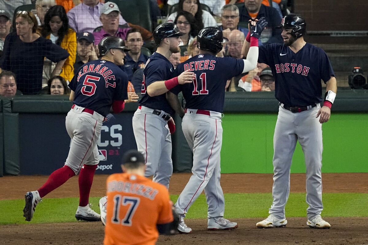 The Red Sox's Rafael Devers (11) celebrates with teammates after hitting a second-inning grand slam Oct. 16, 2021.