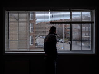 a man looks out of a living room window
