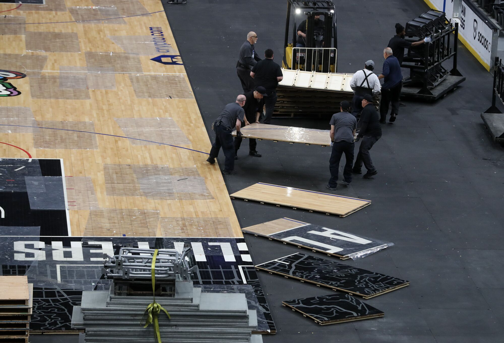Employees switch over Crypto.com Arena playing surfaces from hardwood to ice.
