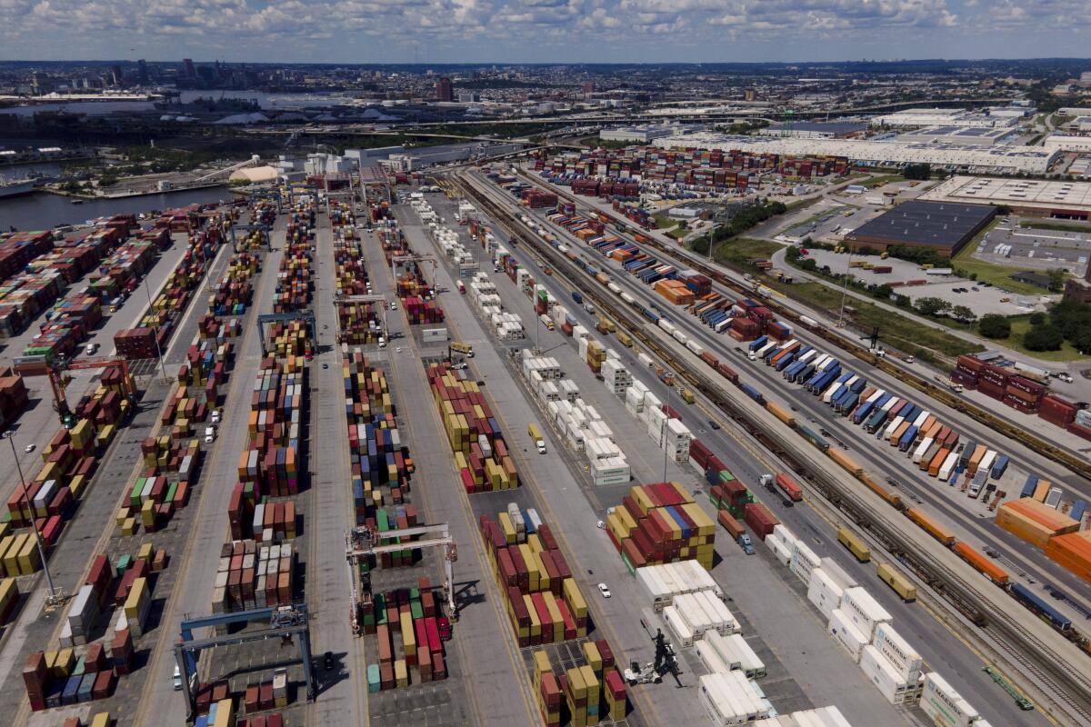 Shipping containers are stacked together at a port.