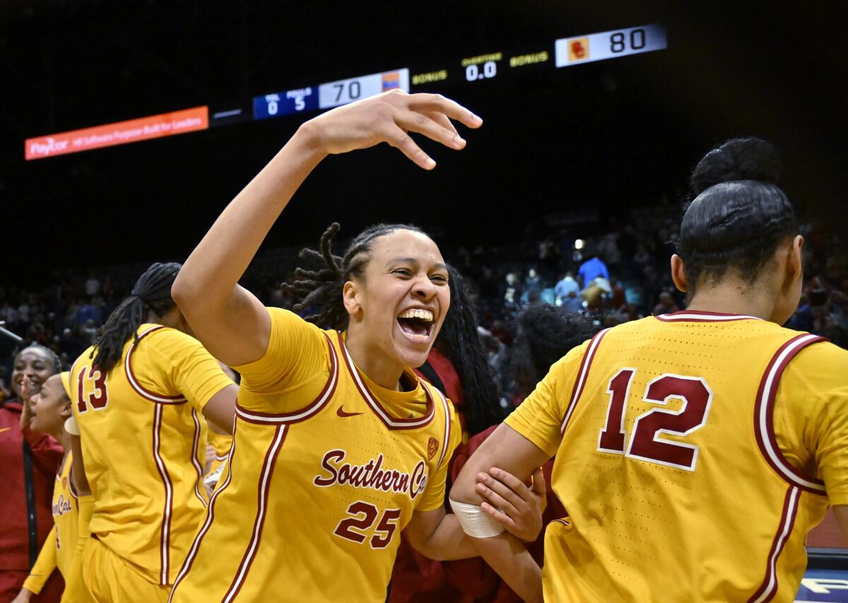 USC guard McKenzie Forbes, center, celebrates with teammates after an overtime win against UCLA.