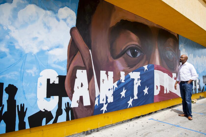 Civil rights attorney Daryl Washington admires a large mural of George Floyd painted on the side of the Breakfast Klub in Houston, TX, on Sunday, June 7, 2020.