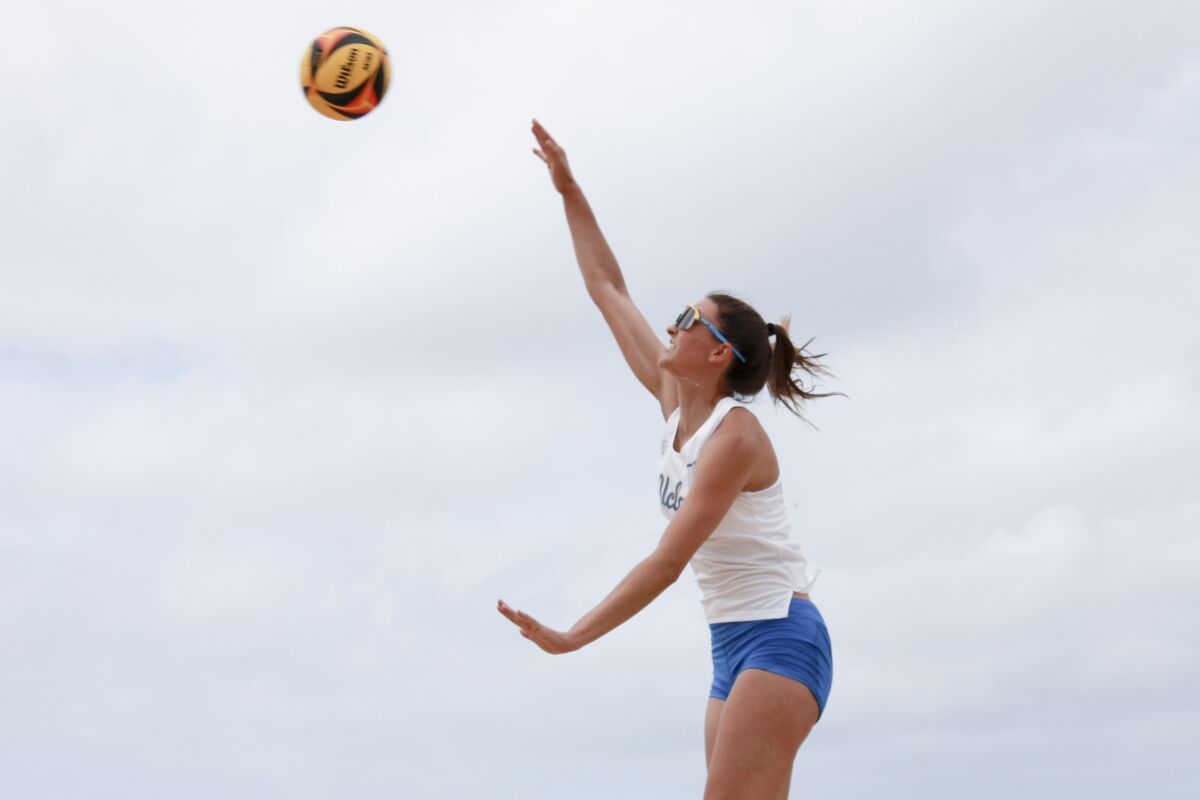Haley Hallgren jumps up to hit a volleyball.