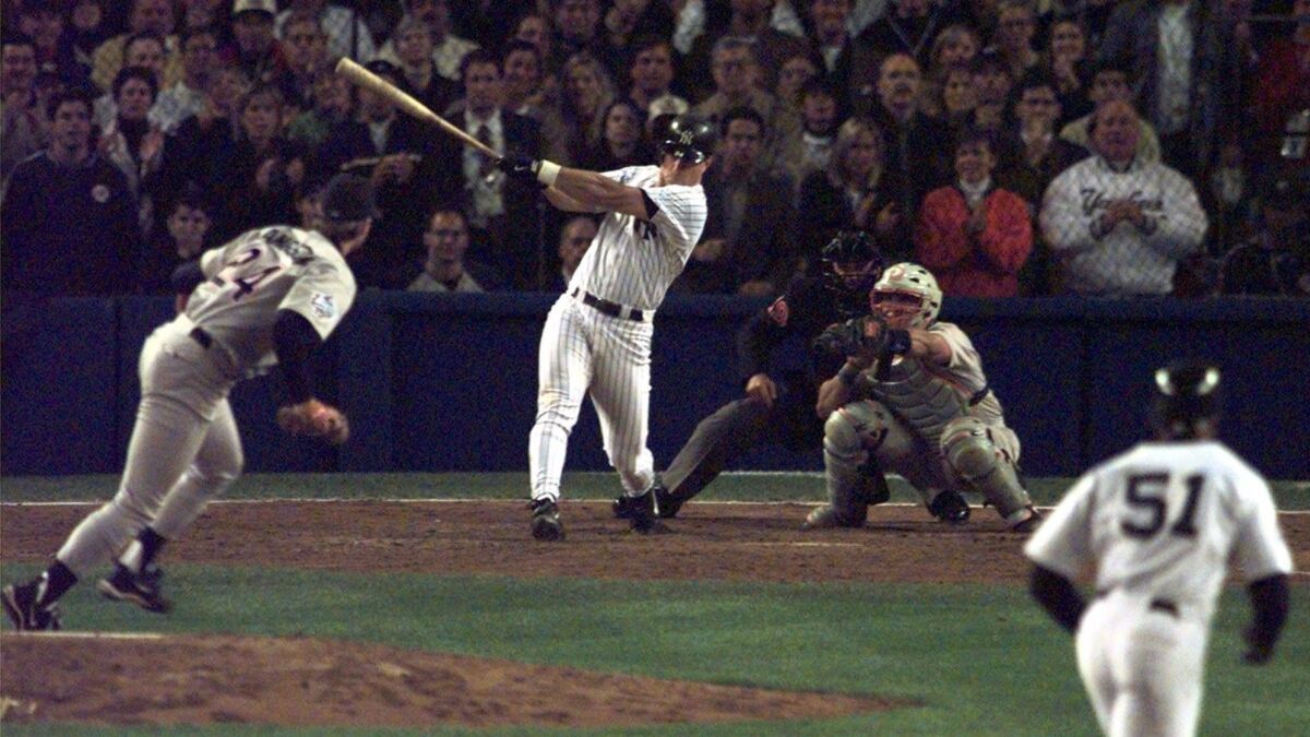 New York Yankees' Tino Martinez hits a grand slam off Padres reliever Mark Langston as Padres catcher Carlos Hernandez and home plate umpire Rich Garcia look on in the seventh inning of the first game of the World Series Saturday, Oct. 17, 1998 in New York's Yankee Stadium.