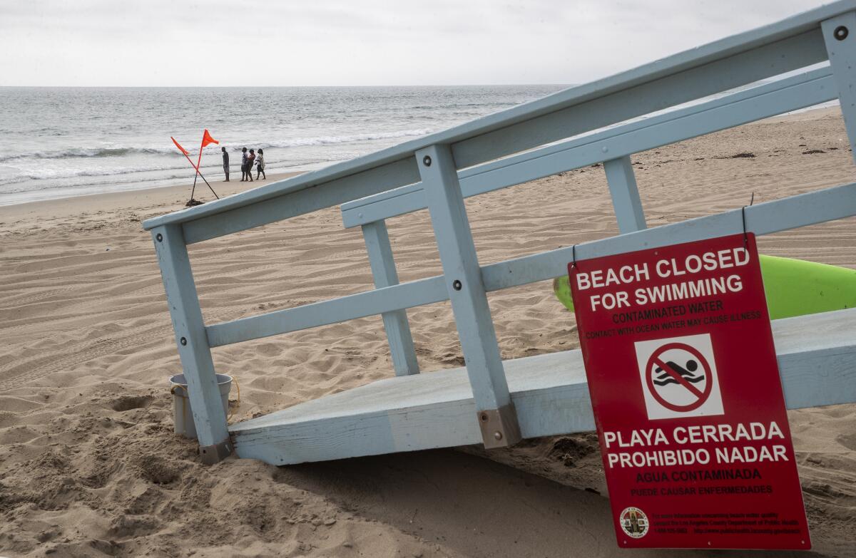 A sign at a lifeguard station warns that Dockweiler State Beach in Playa del Rey is closed to swimming 