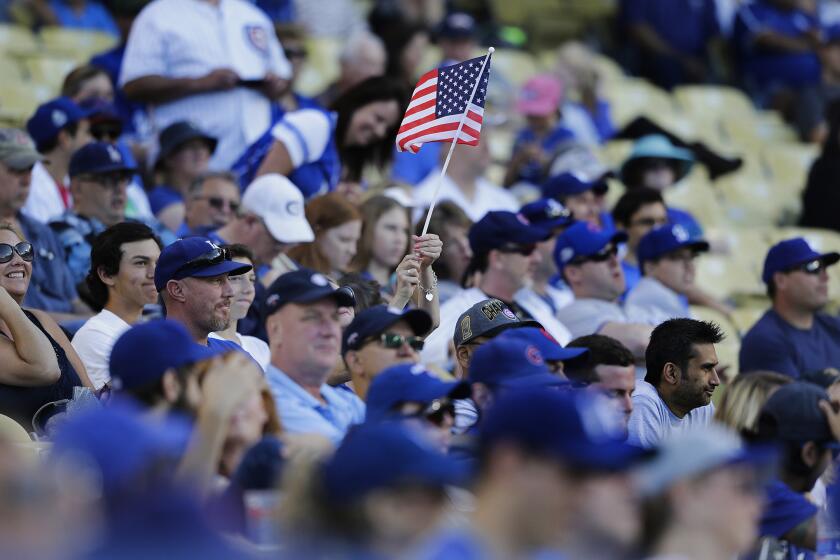 A Dodgers fan waves an American fag during the Memorial Day weekend game against the Chicago Cubs.