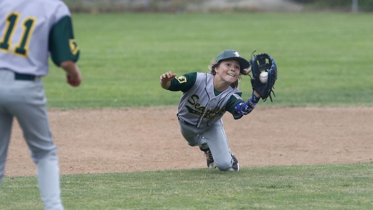 Seaview Little League's Carson Cato makes a diving catch against Costa Mesa National in a Little League District 62 All-Stars Tournament game for 9- and 10-year-olds on Tuesday at Fountain Valley Sports Park.