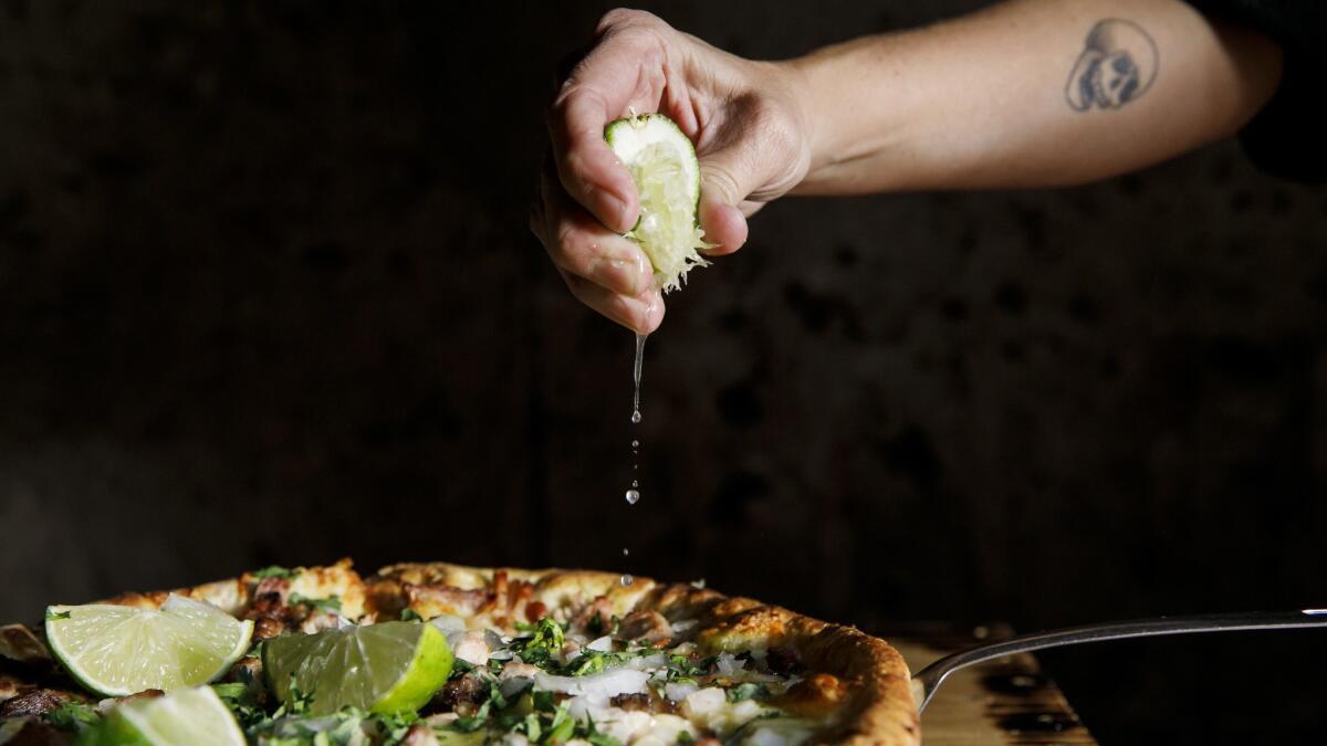 Squeeze some lime juice on Pizza del Perro Negro's carnitas-topped pizza.