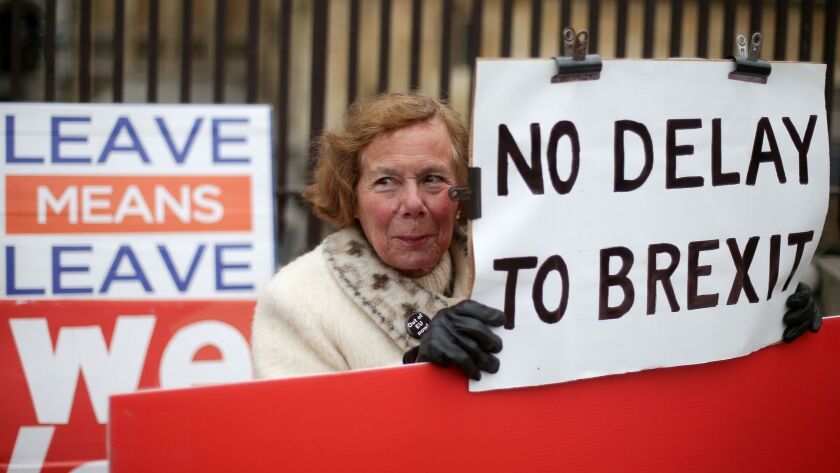 Pro-Brexit activists hold placards as they demonstrate outside the Houses of Parliament in central London on March 20.