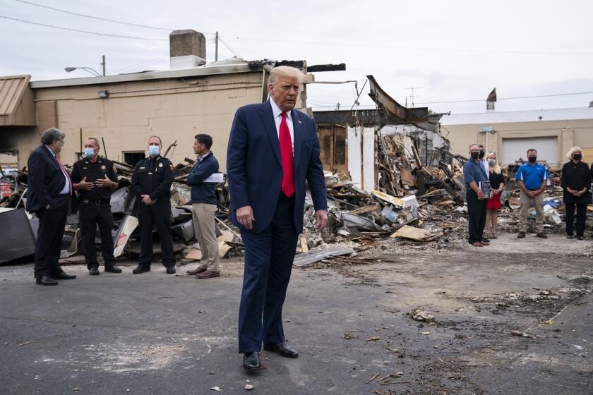 FILE - In this Sept. 1, 2020 file photo, President Donald Trump tours an area damaged during demonstrations after a police officer shot Jacob Blake in Kenosha, Wis. Wisconsin Democrats, stung by President Trump's narrow win four years ago, are confident the lessons they learned will ensure he doesn't do it again. But Republicans say civil unrest that followed a police shooting in Kenosha, and Trump's "law and order" message, will help him win over the crucial white suburban voters he needs to capture a second term. (AP Photo/Evan Vucci File)