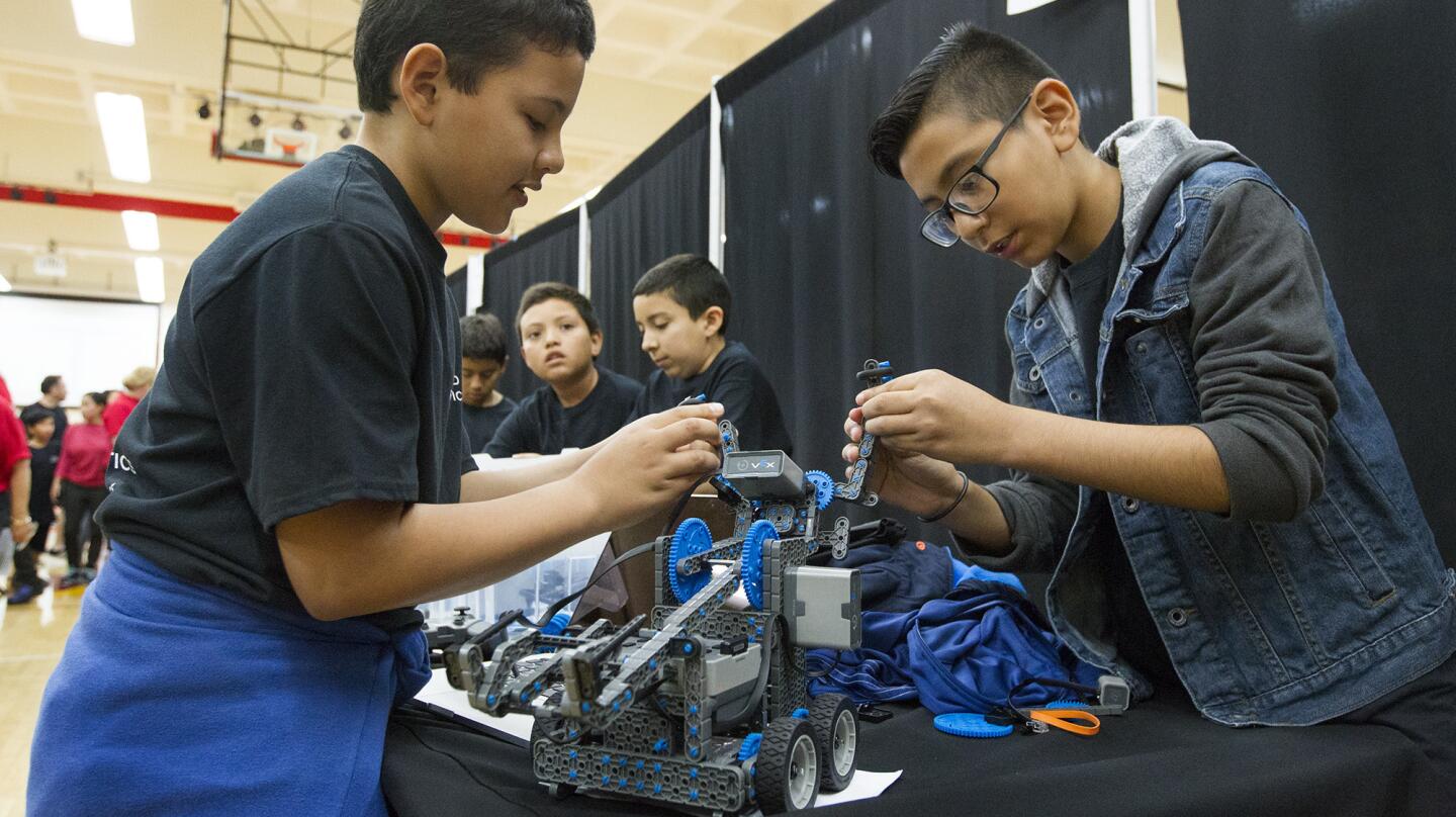 Wilson Elementary School fifth-graders Bastian Tamayo, right, and Eduardo Silva add parts to their teams Vex IQ Clawbot during a NMUSD robotics competition on Saturday at Estancia High School in Costa Mesa. (Kevin Chang/ Daily Pilot)