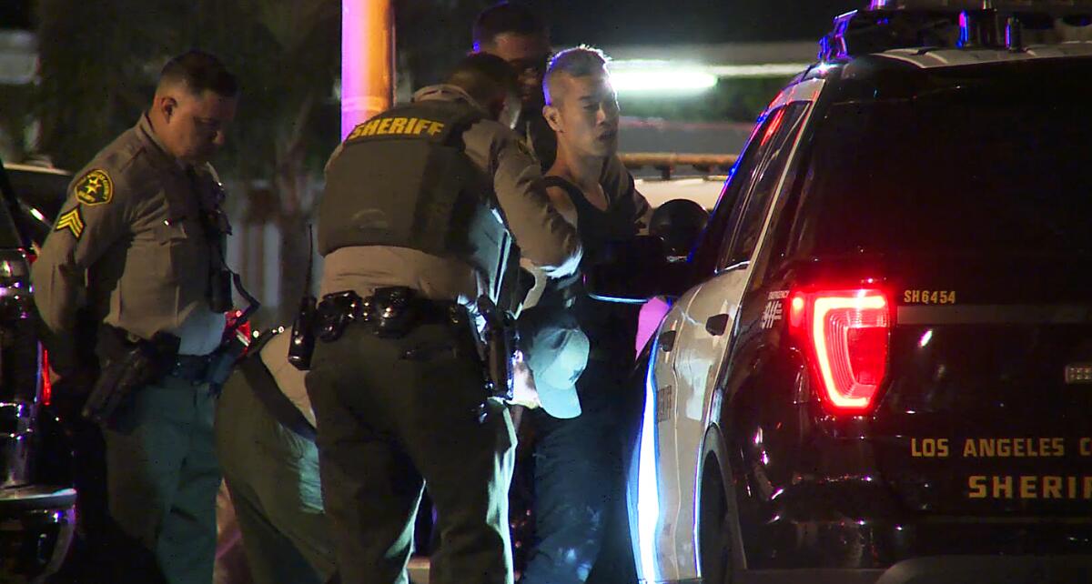 Law enforcement officers arresting a shooting suspect at night 
