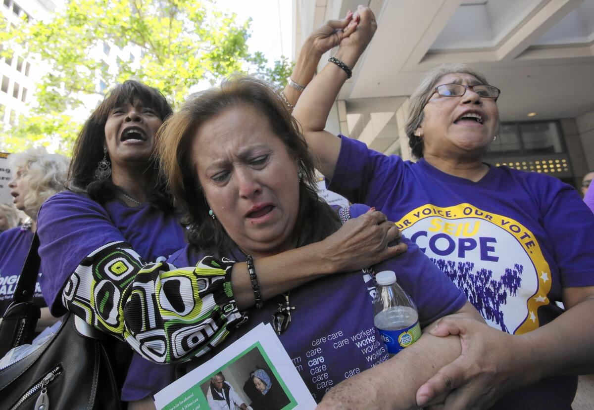 Home-care workers Juanita Williams, Zoila Ramirez and Bethzalie Saldana take part in a protest rally in downtown Los Angeles in 2014. The workers and their unions have fought for the right to be paid overtime.