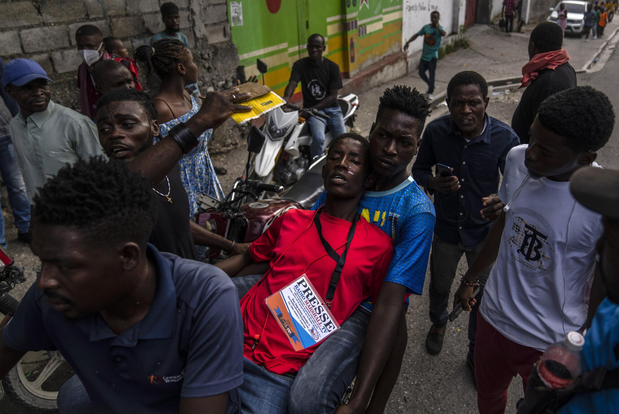 People help a journalist overcome by tear gas,