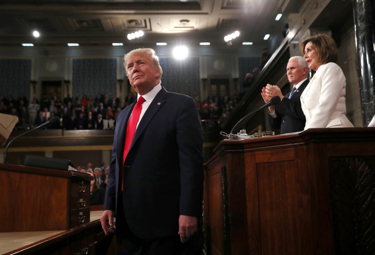 President Trump arrives to deliver his State of the Union address to a joint session of Congress, as Vice President Mike Pence and Speaker Nancy Pelosi look on.