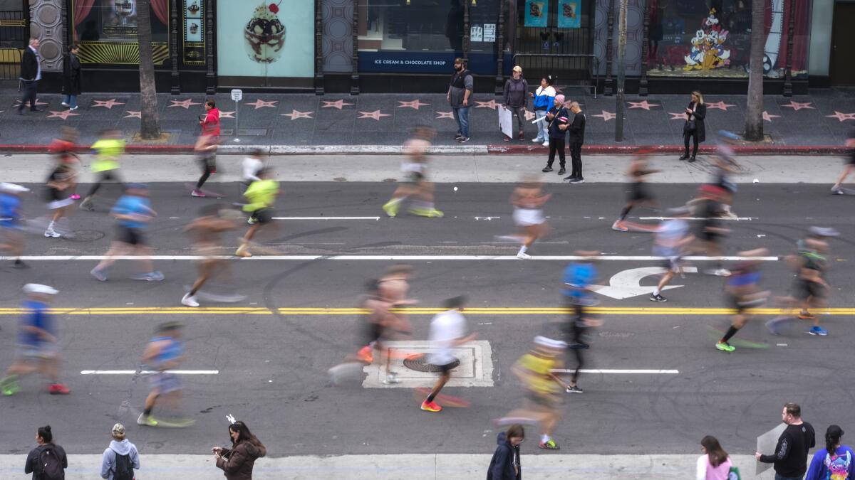Runners run along Hollywood Boulevard during the 38th LA Marathon in Los Angeles, Sunday, March 19, 2023. (Photo by Ringo Chiu / For The Times)