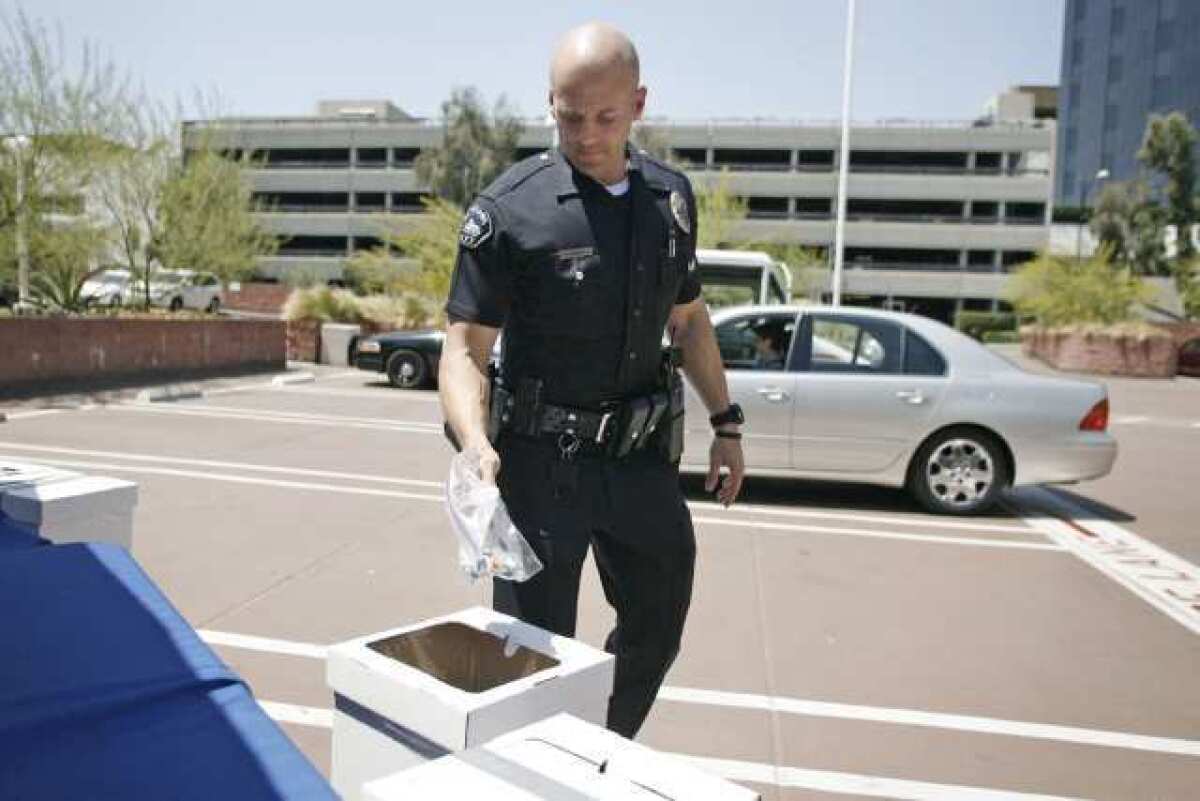 Burbank Police Officer Joshua Kendrick takes prescription drugs from residents during the event on Saturday.